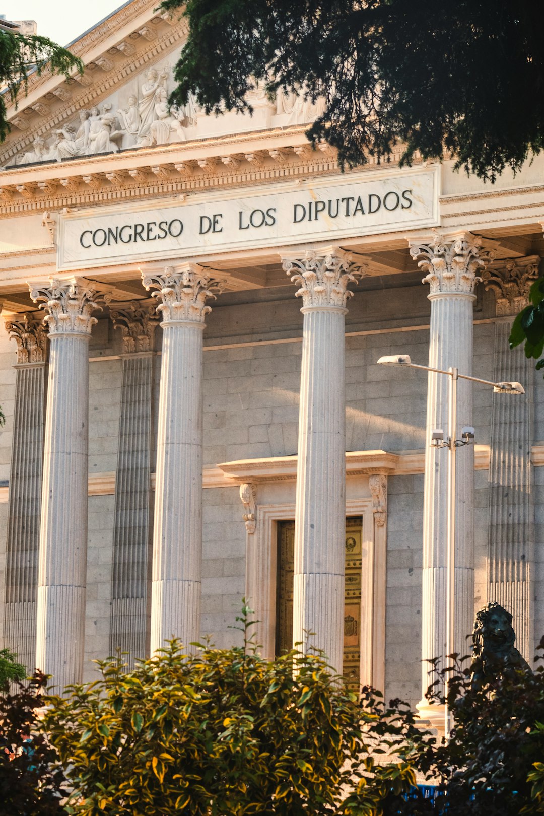 the-front-of-a-building-with-columns-and-a-clock-xkzqetdkcoc
