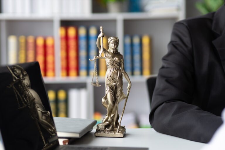 Estatua de la Justicia frente a libros de derecho